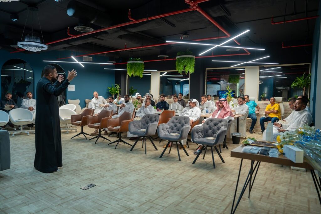 التجار يتابعون العرض في القاعة.